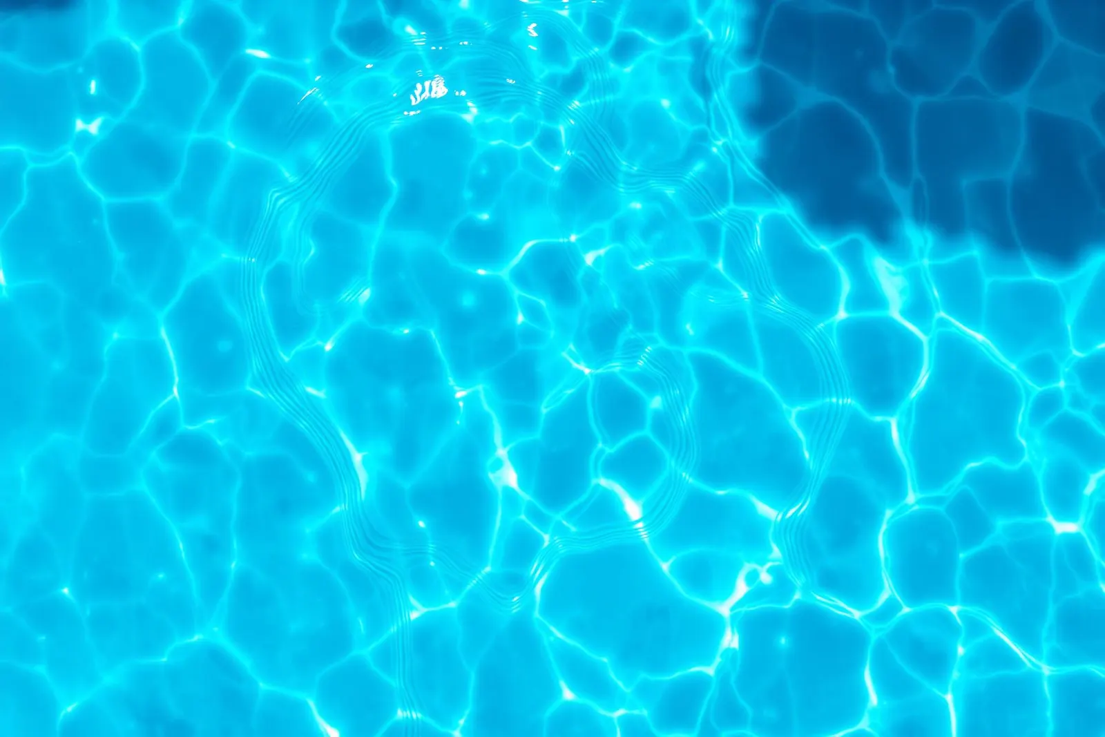 Sparkling sunlit blue pool water surface